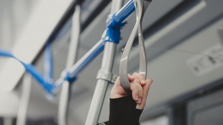 the-hand-of-a-woman-holding-on-to-the-handrail-fro-2023-11-27-05-29-26-utc
